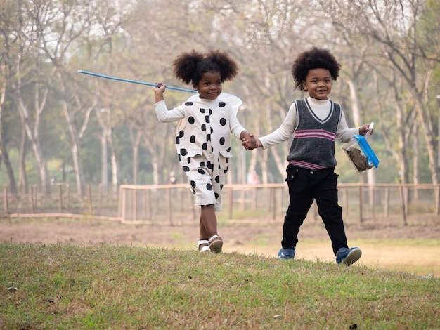 African American boys and girls catch insects in the forest on adventure camping travel trips Preschool kids catching bugs with net Adventure kindergarten day trip into wild naturexAxA