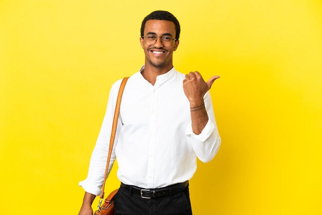 African American business man over isolated yellow background pointing to the side to present a product