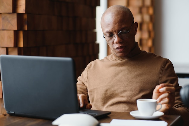 African american business man with laptop in a cafe