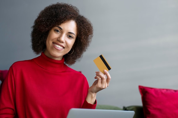 African American business woman holding credit card using laptop shopping online