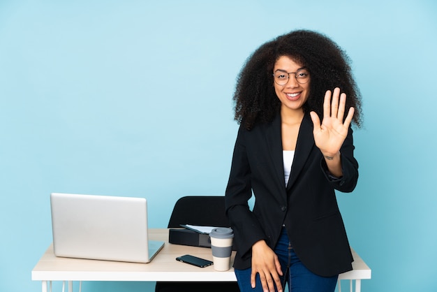 指で5を数える彼女の職場で働くアフリカ系アメリカ人ビジネスの女性