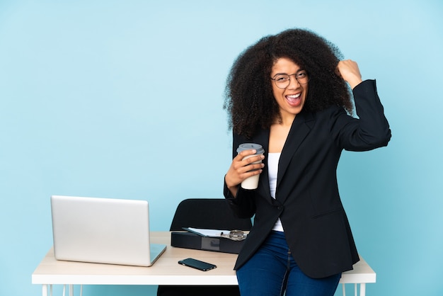 Donna afroamericana di affari che lavora nel suo posto di lavoro facendo un gesto forte