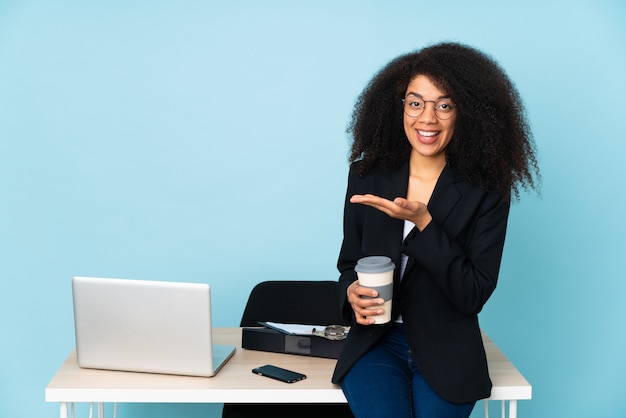 African american business woman working in her workplace presenting an idea while looking smiling towards