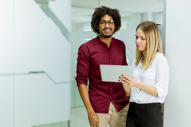 African american businessman and caucasian businesswoman with tablet pc computer standing in office