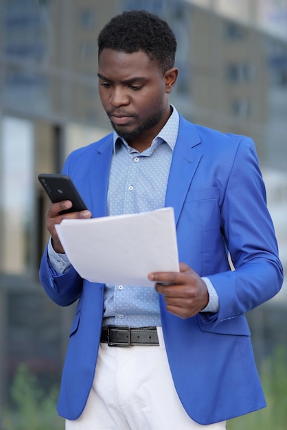 Афро-американский бизнесмен изучает ежемесячный бумажный отчет