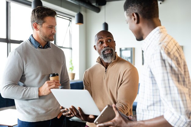 African american businessman explaining strategy to colleagues over laptop in office