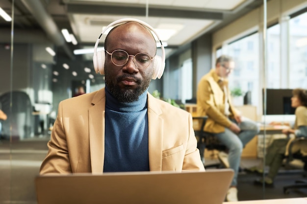 African American businessman in headphones watching online video