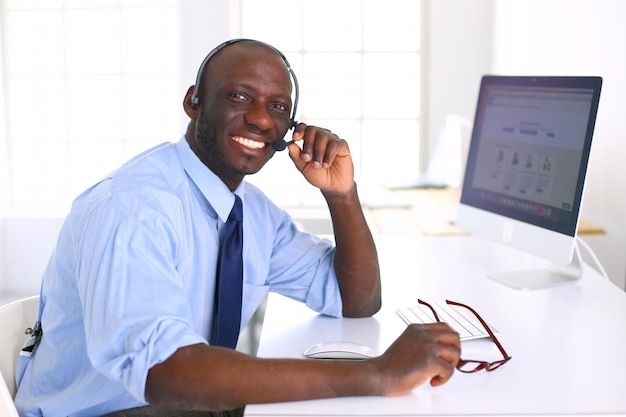 African american businessman on headset working on his laptop
