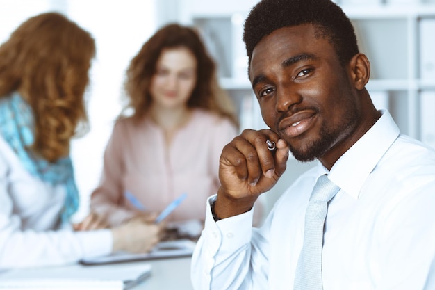 African american businessman at meeting in office, colored in white. Multi ethnic business people group.