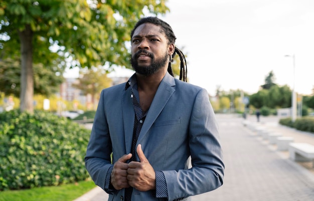 African American businessman in stands in front of the camera very serious