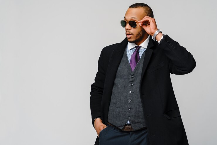African-american businessman wearing coat over light grey wall