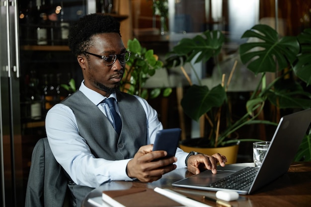 African american businessman working on laptop in cafe