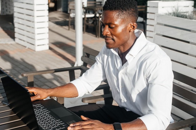 African-American businessman working at a laptop in a cafe