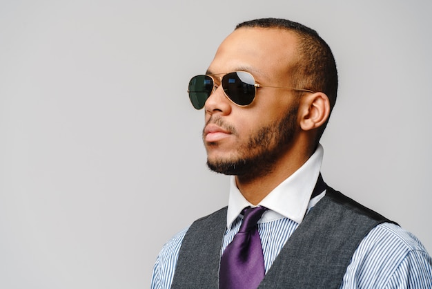 African-American businessmanman wearing glasses portrait over grey