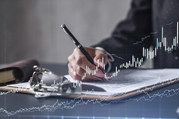 African american businesswoman in formal wear is signing the\
contract to invest money in stock market internet trading and\
wealth management forex and financial hologram chart