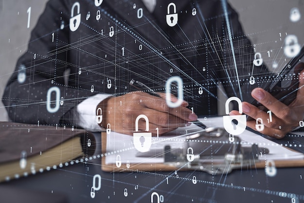 African American businesswoman in formal wear signing the contract to prevent probability of risks in cyber security Checking the phone Padlock Hologram icons over the working desk