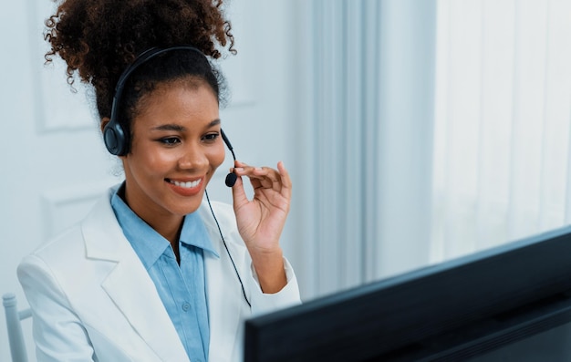 African American businesswoman wearing headset working in office to support remote crucial customer or colleague Call center telemarketing customer support agent provide service on video call