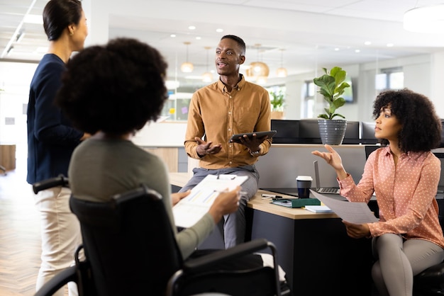 African american businesswoman on wheelchair and diverse people in office talking. Business, corporation, working in office concept.