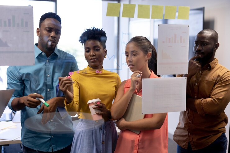 Photo african american businesswoman writing strategy on glass wall amidst biracial colleagues at office