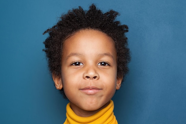 African American child boy face closeup on blue background