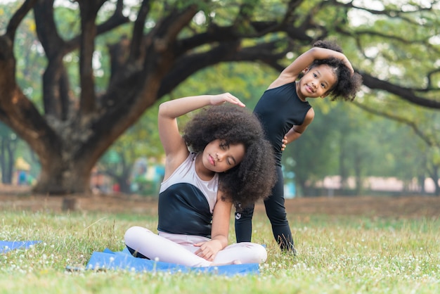 African american children practice yoga in the park outdoor