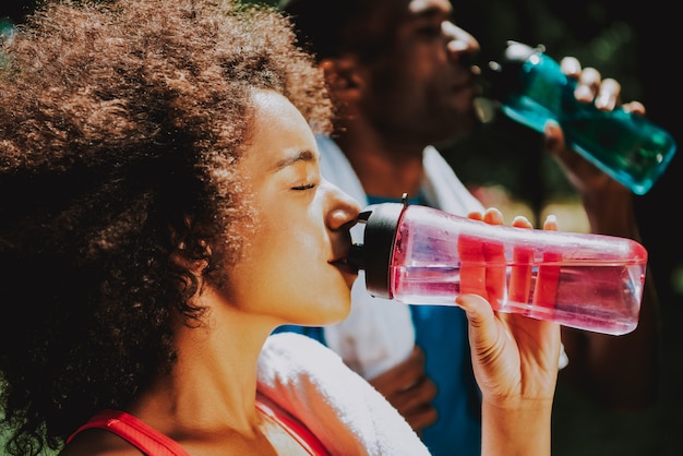 Photo african american couple drinking water in wood