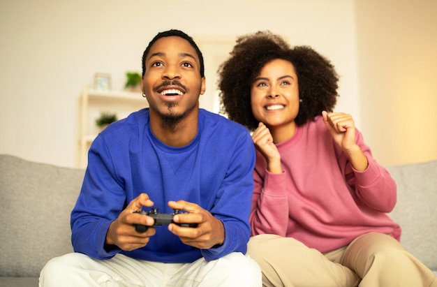 African american couple enjoying gaming session with digital gamepad indoor