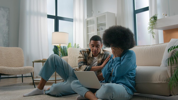 African american couple sit on floor at home living room woman girl wife upset sad suffer problem