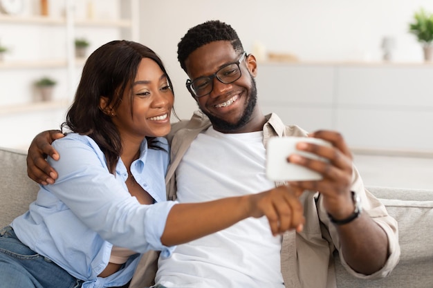 Premium Photo | African american couple sitting on couch using cellphone