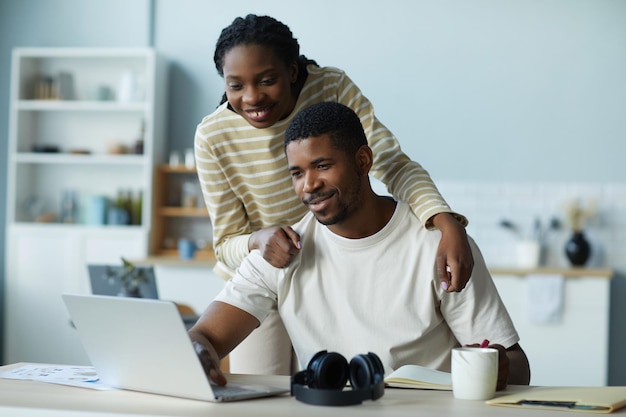 African american couple watching video on laptop