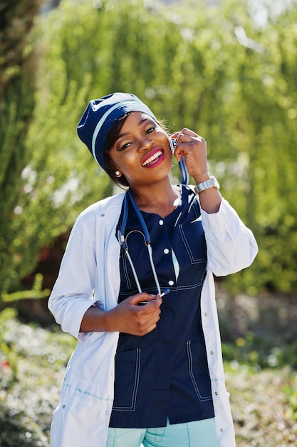 Африканская женщина-врач со стетоскопом позирует на открытом воздухе
