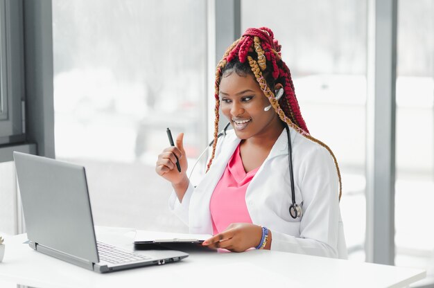 African American doctor in headset consulting with the patient over the phone call