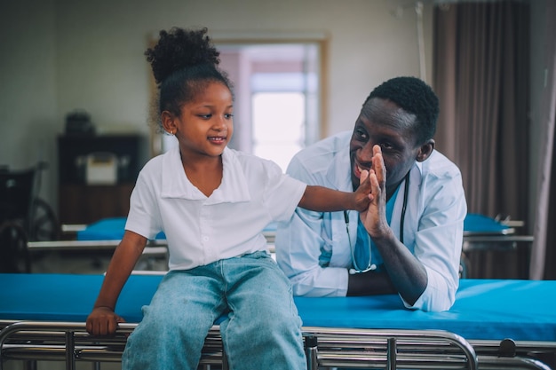 African American doctor pediatrician with kid patient in hospital