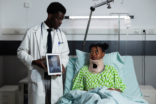 African american doctor showing x ray tablet to patient