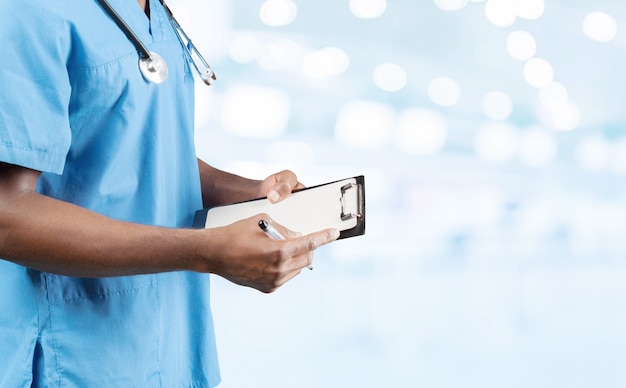 African american doctor with a stethoscope standing against blurred background