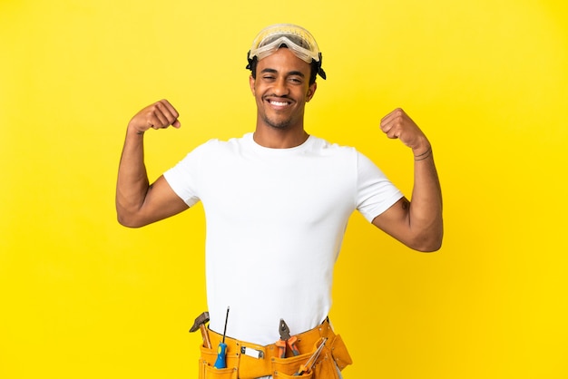 African American electrician man over isolated yellow wall doing strong gesture