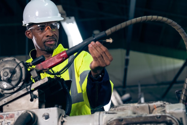 African American factory worker working with adept robotic arm