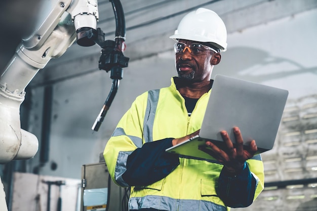 African American factory worker working with adept robotic arm