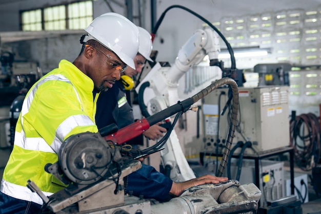 African American factory worker working with adept robotic arm