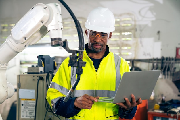 African American factory worker working with adept robotic arm