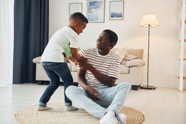 Отец афроамериканца со своим маленьким сыном дома