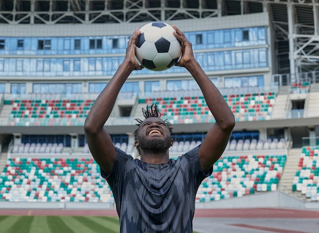 African american football player holding the ball in his hands at the stadium