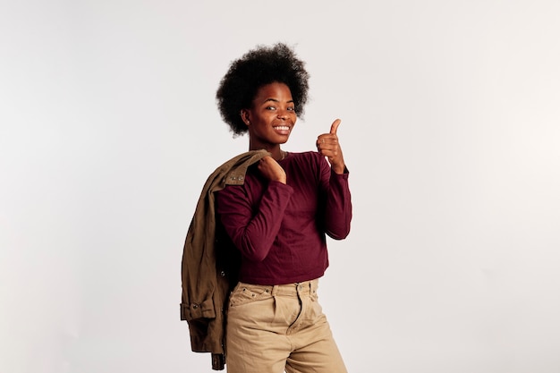 그녀의 손을 보여주는 갈색 스웨터 포즈에 아프리카계 미국인 여자