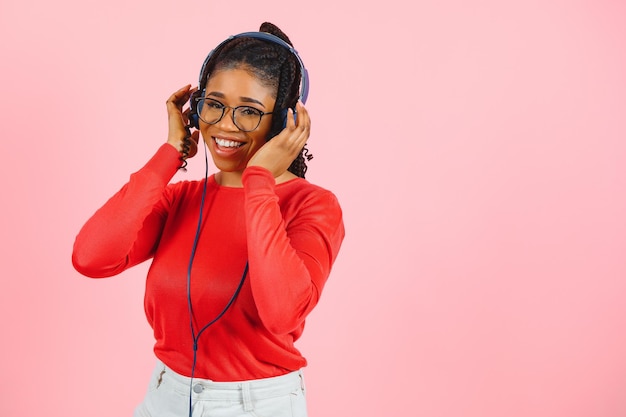 African american girl in headphones on a pink background