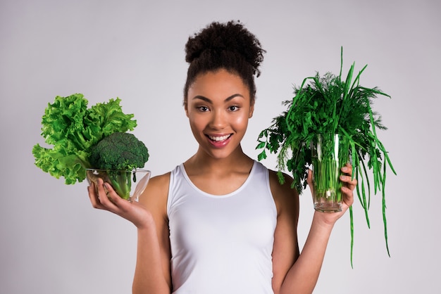 African American girl holding greens isolated.