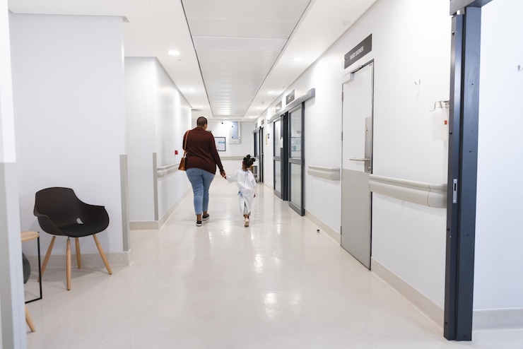 Photo african american girl patient and her mother walking in corridor at hospital. hospital, motherhood, family, medicine and healthcare, unaltered.