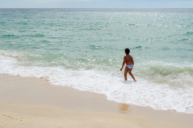 African American girl playing in the water on the seashore