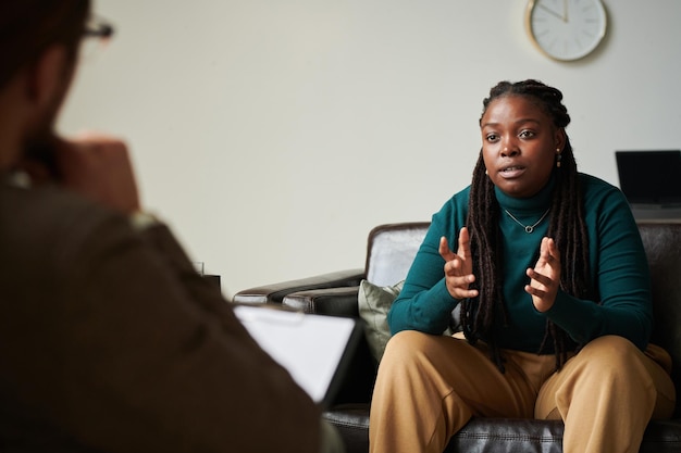 Photo african american girl talking to psychologist at office