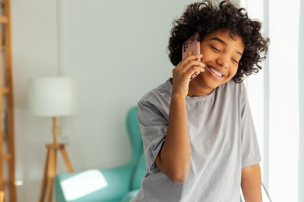 African american girl talking on smartphone at home indoor young woman with cell phone chatting with