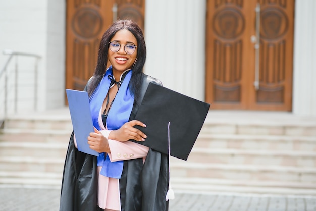 African American graduate holding diploma.